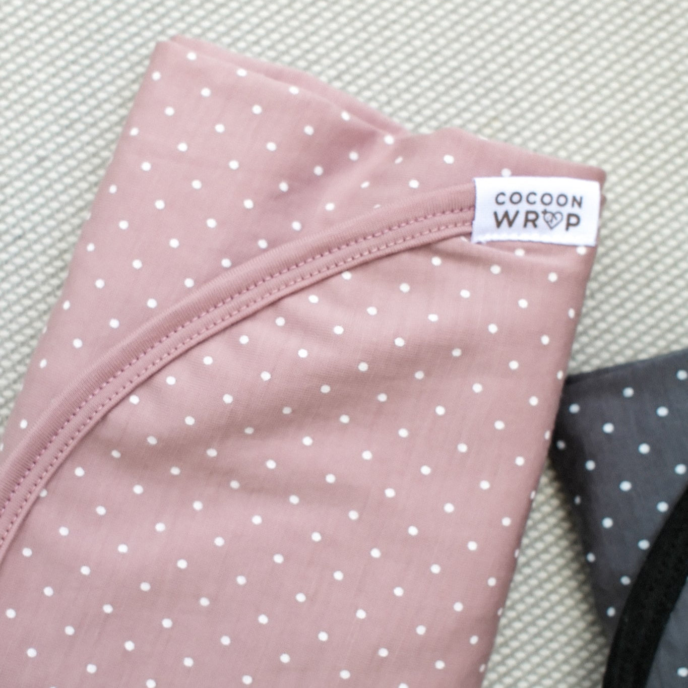 Pink wrap with white polka dots and a visible brand label on a textured surface.