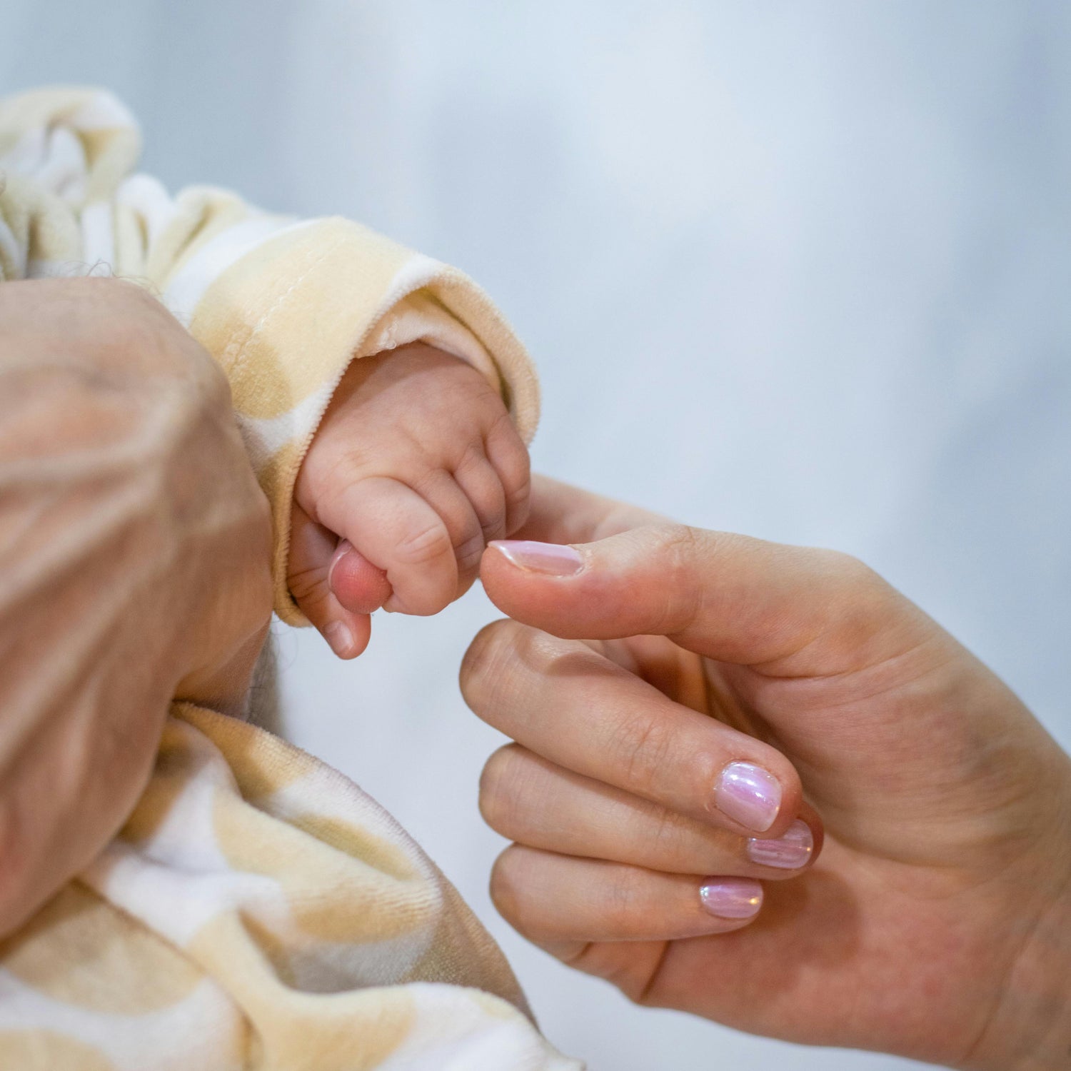 mum folding baby finger