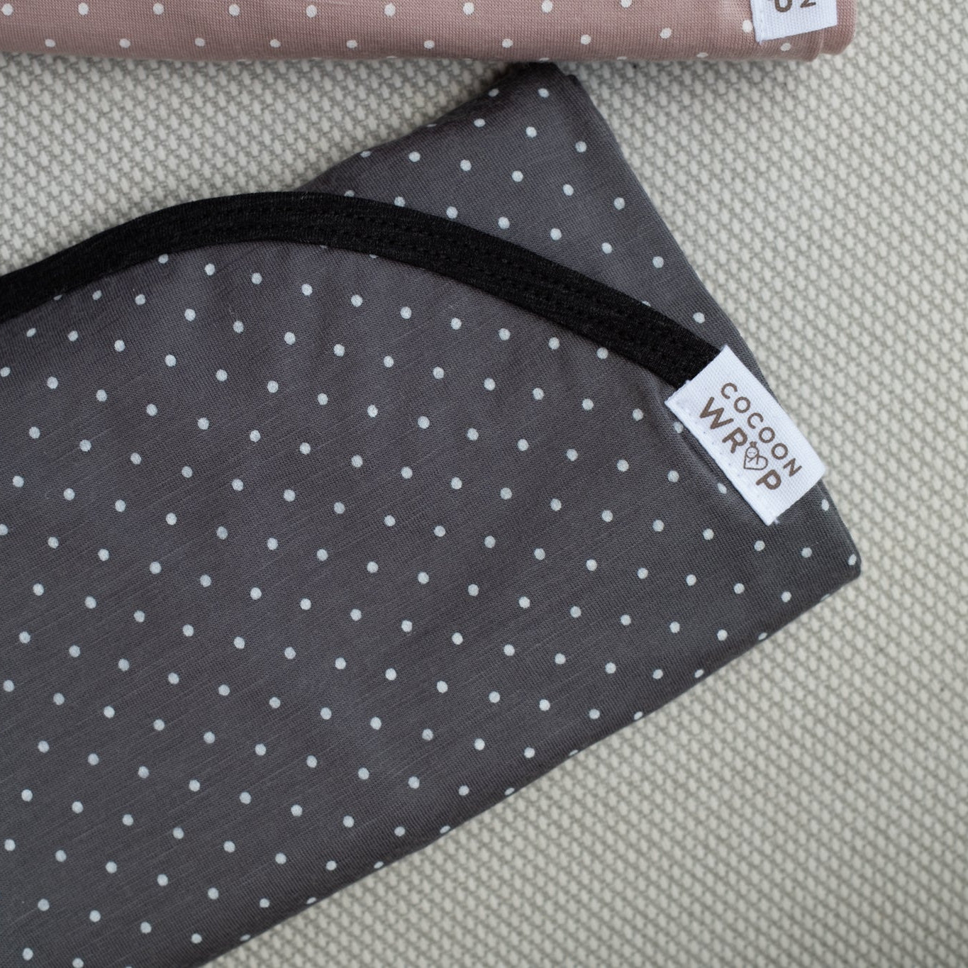 Gray fabric with white polka dots on a textured surface